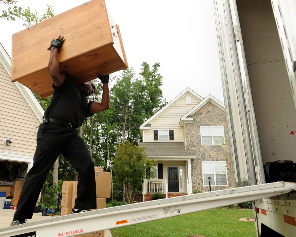 LANGLEY AIR FORCE BASE, Va. - Eric Andrews, warehouse worker/packer carries a cabinet to the moving truck July 23.(U.S. Air Force photo/Airman 1st Class Gul Crockett)
